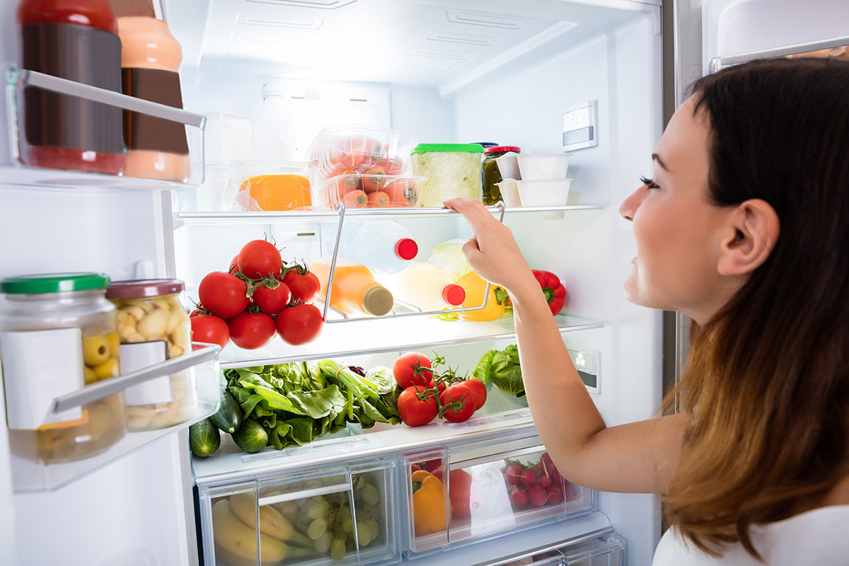 Ahorro de luz con aparatos electrodomésticos, foto ilustrativa de una mujer abriendo el refrigerador