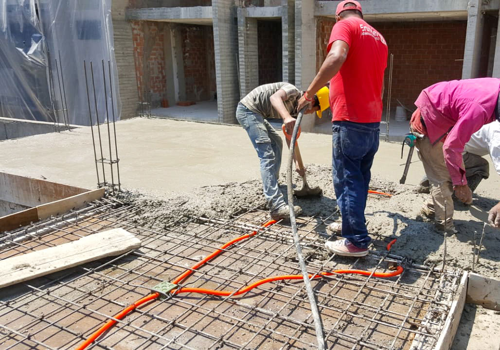 Foto de albañiles haciendo colado de concreto en una construcción