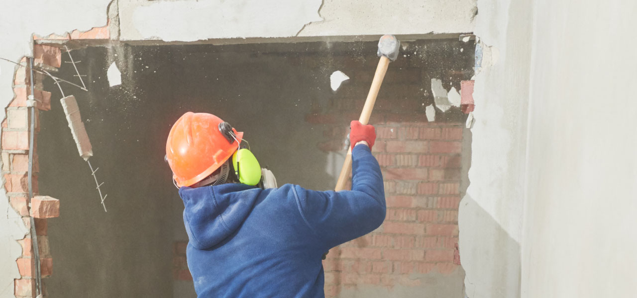 Imagen de albañil tirando un muro para demolicion 