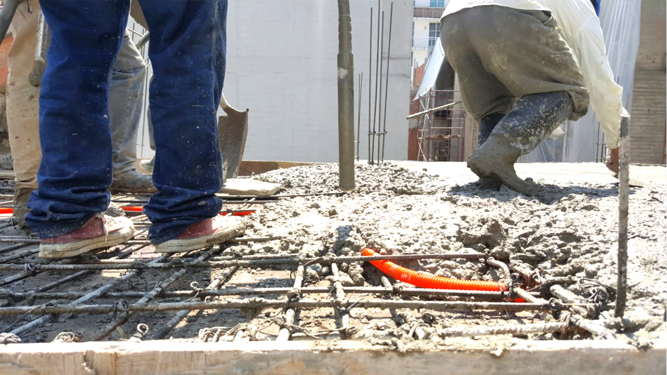 Imagen de albañiles colocando el concreto en una construcción