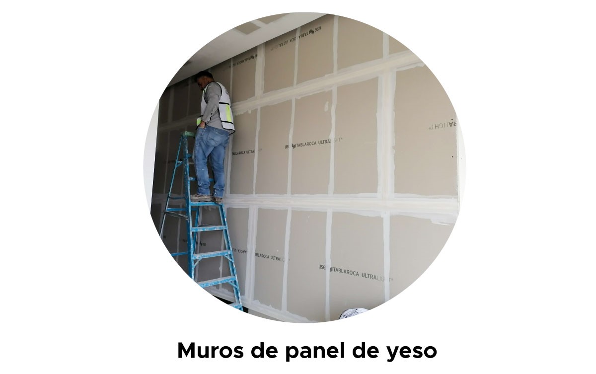 Fotografía de un albañil colocando panel de yeso en muros