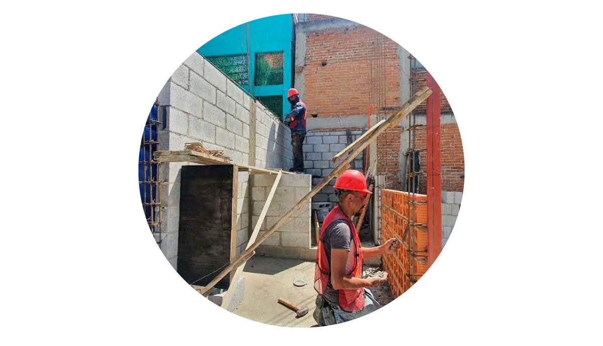 Fotografía de albañiles trabajando en la construcción o ampliación de una planta baja 