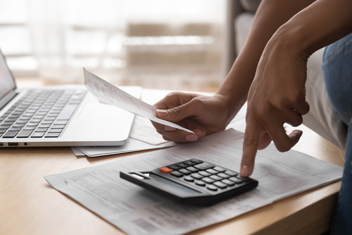 Foto de una persona haciendo cuentas con una calculadora, para verificar el monto de su pago predial 