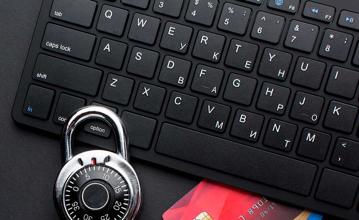 Imagen ilustrativa de un teclado de computadora con una tarheta de crédito debajo y un candado de seguridad, simulando el cuidado con los creditos en línea