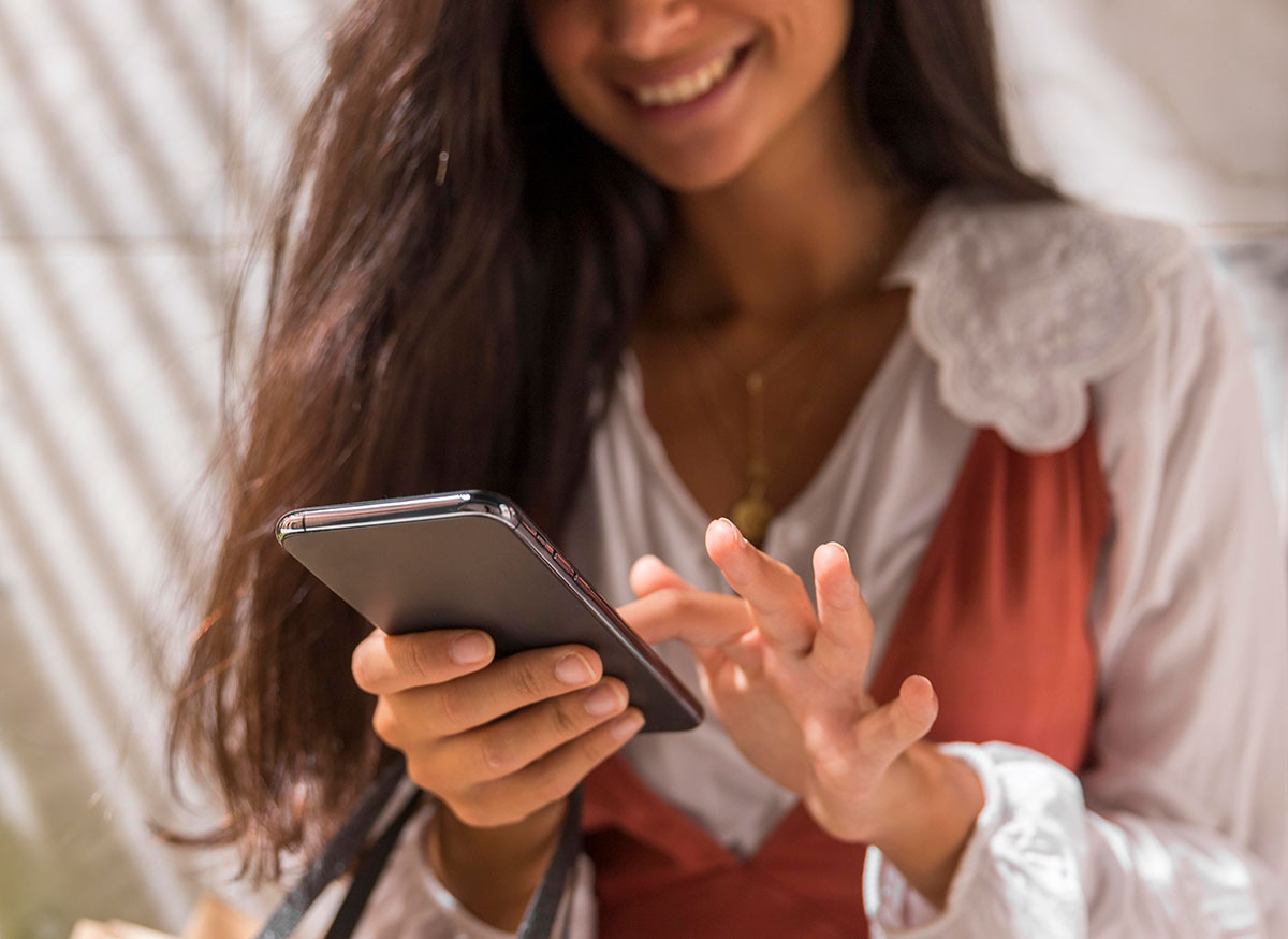 Fotografía de mujer interactuando con su celular para buscar creditos en línea